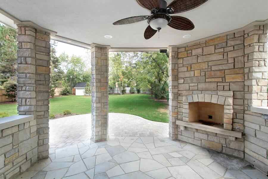 Covered patio with fireplace and stone columns.