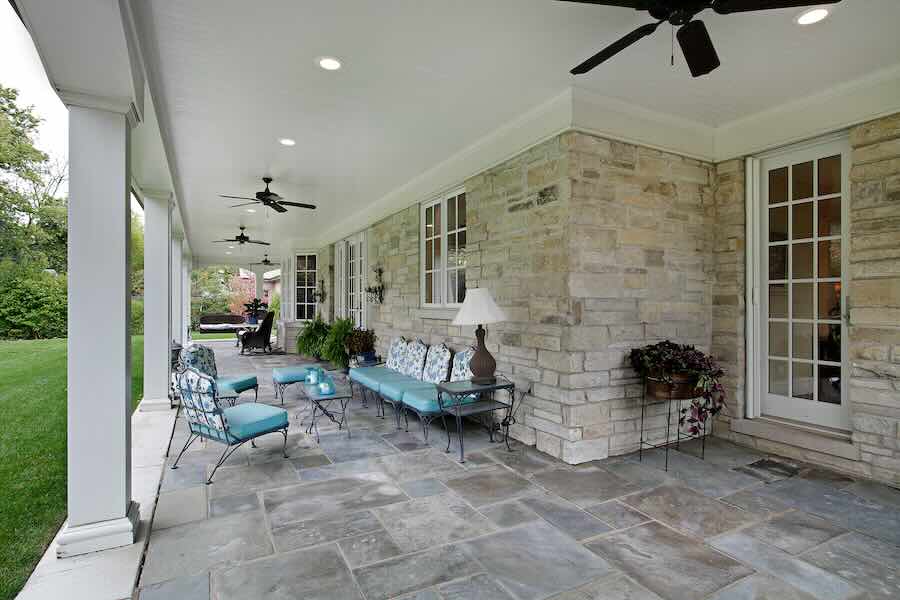 Covered patio with seating and stone walls.