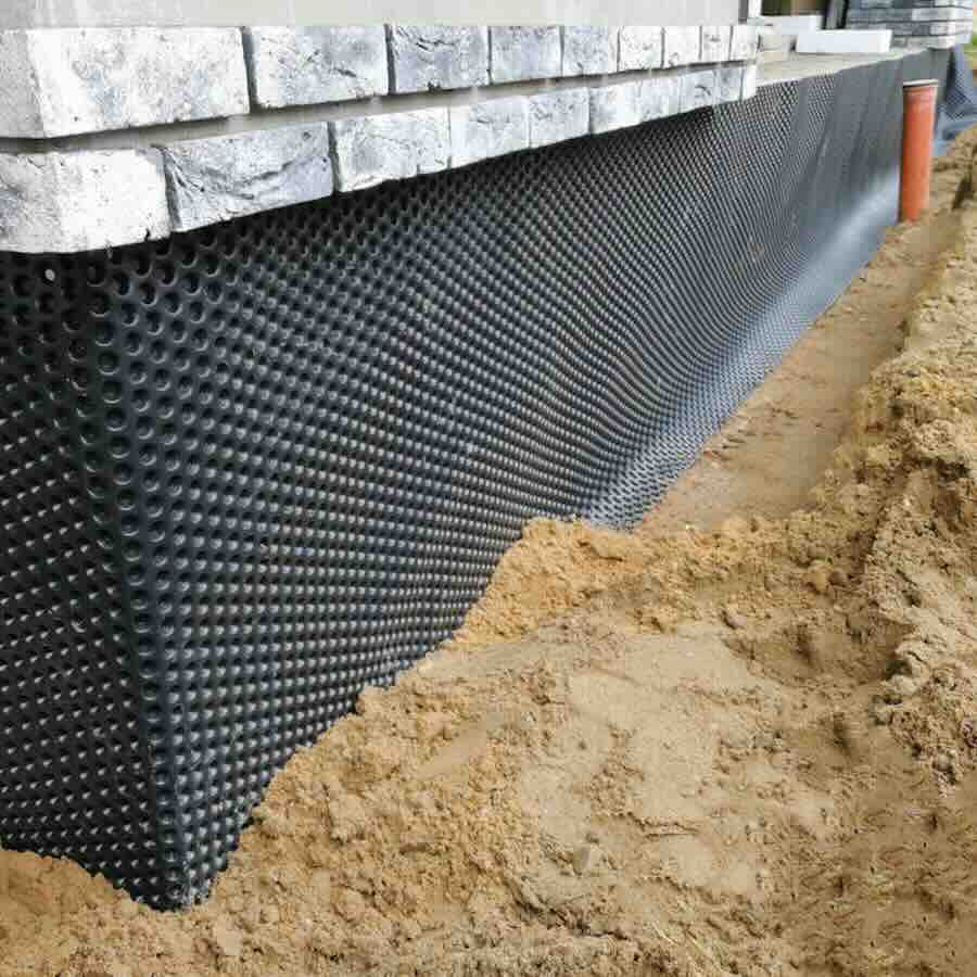 Black plastic drainage membrane fixed on the foundation of house under construction
