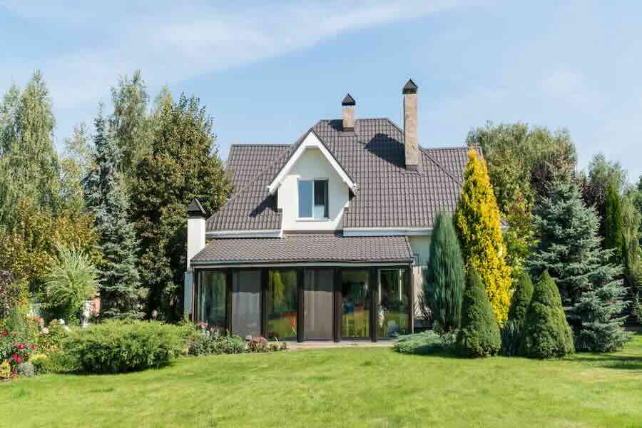 Charming house with lush garden and trees.