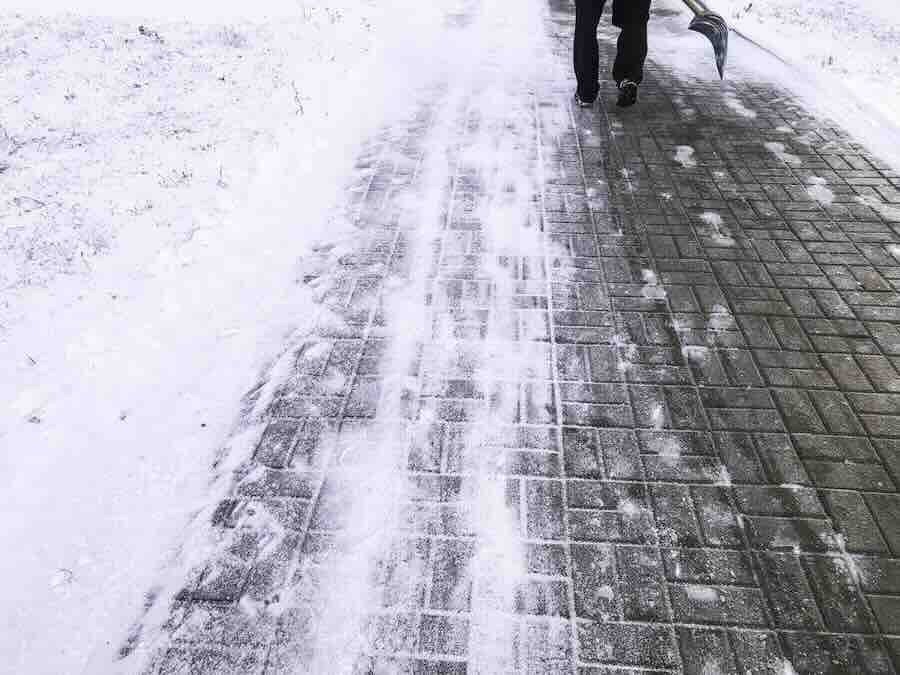 Worker sweep snow from road in winter